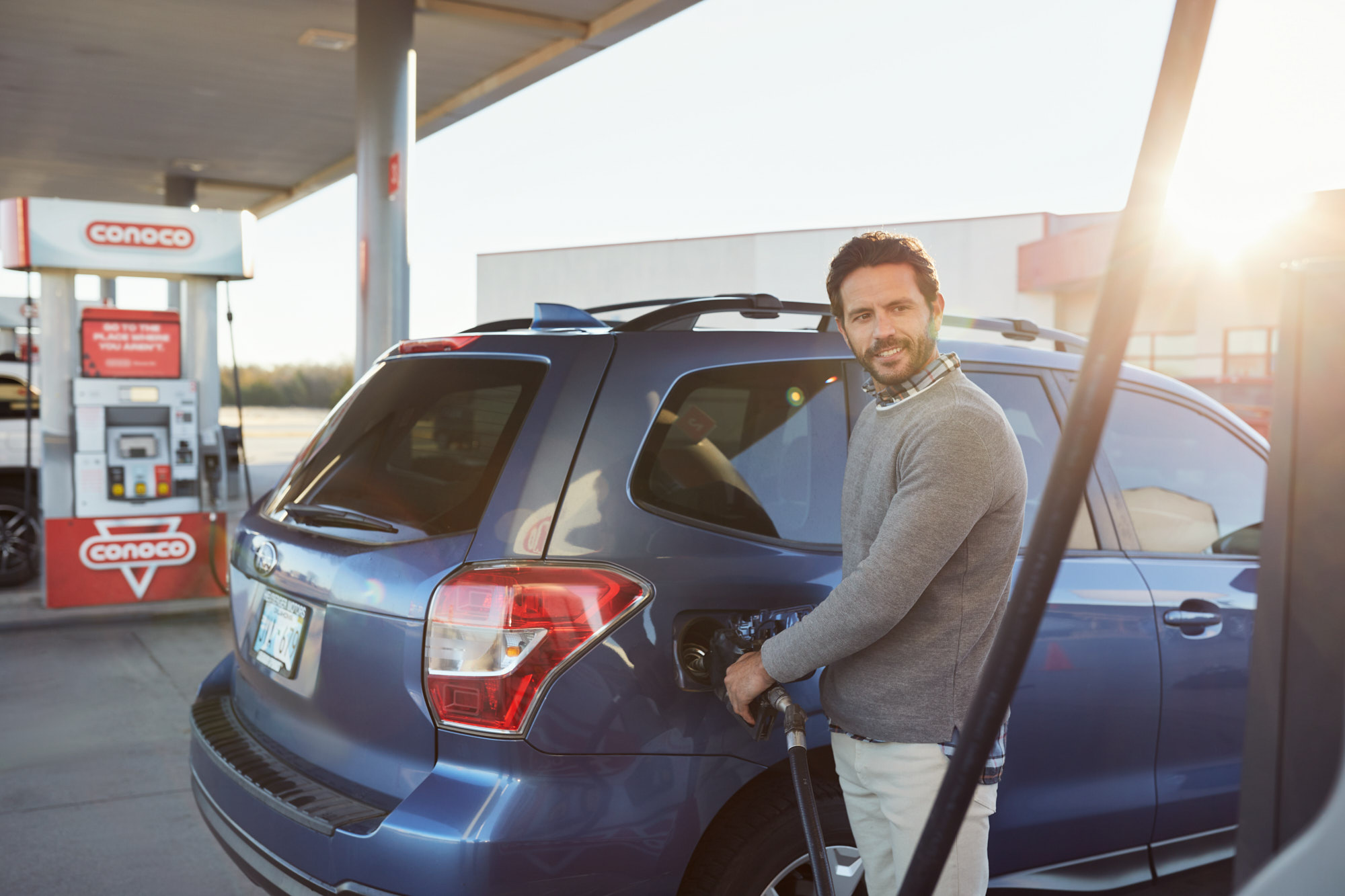 Man Smiles at Gas Pump | Brand Lifestyle Photography